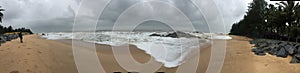 A panoramic view of the Kundapura beach under cloudy skies