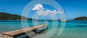 Panoramic sea and harbor view with wooden pier at the beach of Bequia, St Vincent and the Grenadines.