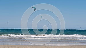 Panoramic sea view with kitesurfing sails. people enjoy riding a kitesurfing board on a bright sunny day, by the sea or