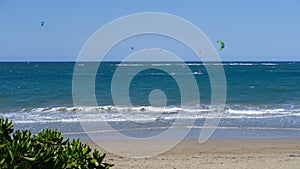 Panoramic sea view with kitesurfing sails. people enjoy riding a kitesurfing board on a bright sunny day, by the sea or