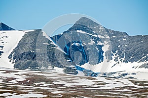 Panoramic shot of beautiful mountain peaks and landscape scenery in spring with snow capped mountains