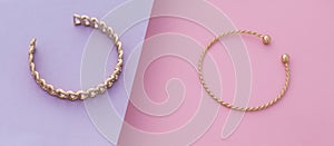 Panoramic shot of Chain and spiral shape bracelets on pink and purple background
