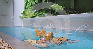 A panoramic shot of floating breakfast in blue swimming pool, luxury resort