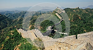 Panoramic shot of the Great Wall surrounded by forested mountains in China