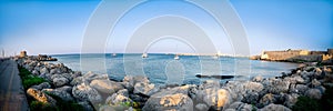 Panoramic shot of multiple sailboats docked along the tranquil shoreline of a tranquil bay