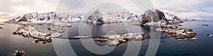 Panoramic shot over Norway Lofoten aerial landscape in winter time with rainbow and mountains covered in snow