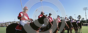 Panoramic shot of polo players and umpire on horses at field