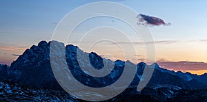 Panoramic shot of the rocks covered with snow in the Italian Alps during the beautiful sunset