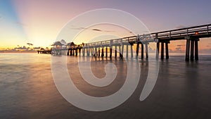 A panoramic shot of a scenic colorful sunset at the beach - Naples Pier, Florida