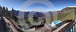 Panoramic shot of scenic mountain ranges with wooden path in the forground