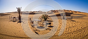 Panoramic shot of tables and chairs in the Sahara Desert in Morocco