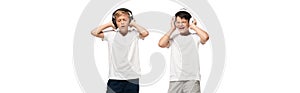 Shot of two excited brothers holding hands on headphones while listening music isolated on white