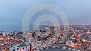 Panoramic skyline of Lima city from above with many buildings aerial night to day transition timelapse. Lima, Peru