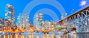 Panoramic skyscrapers reflection along False Creek riverside in Vancouver BC at blue hour