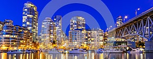 Panoramic skyscrapers reflection along False Creek riverside in Vancouver BC at blue hour