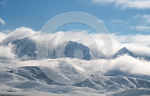 Panoramic snow mountain with white clouds and blue sky