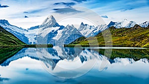 Panoramic summer view of Bachalpsee lake with Schreckhorn and Wetterhorn peaks on background. Gloomy outdoor scene of Swiss Bernes