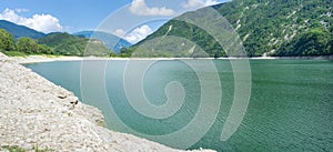 Panoramic summer view on mountain lake Corlo in Italy, surrounded by the Alps.