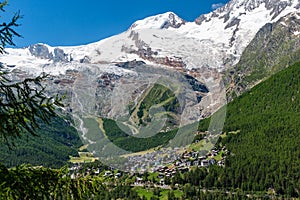 Panoramic summer view of Saas-Fee holiday village and surrounding mountains from Saas-Grund, Valais, Switzerland