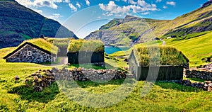 Panoramic summer view of Saksun village with typical turf-top houses and Saksunar Kirkja, Faroe Islands. Sunny morning scene of St