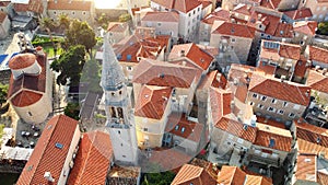 Panoramic sunset aerial drone view of ancient city of Budva, Montenegro. Old medieval town with red roofs. Kotor bay, coast of