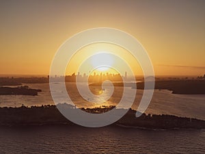 Panoramic sunset aerial drone view of famous Sydney Harbour with the CBD city centre skyline in the background. South Head