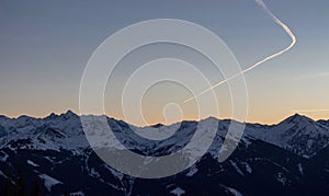 Panoramic sunset view chemtrails Saalbach snowy mountains chemtrail sunset sky from plane