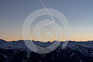 Panoramic sunset view chemtrails Saalbach snowy mountains chemtrail sunset sky from plane