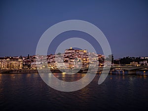 Panoramic sunset view of Coimbra old historical center on hill and Ponte de Santa Clara bridge river Mondego Portugal