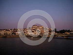 Panoramic sunset view of Coimbra old historical center on hill and Ponte de Santa Clara bridge river Mondego Portugal