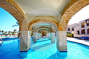 Panoramic swimming pool under bridge in resort