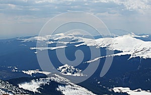 Panoramic view above the mountain ridges covered by snow