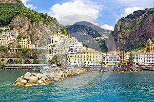 Panoramic view, aerial skyline of small haven of Amalfi village with tiny beach and colorful houses located on rock. Tops of