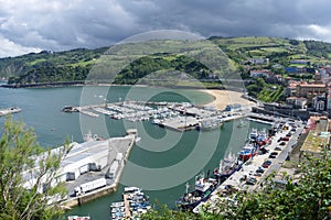Panoramic view and aerial take of the fishing port of Guetaria with many boats on a summer day