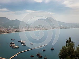 Panoramic view of Alanya, nautical vessels in the harbor and mountains. Alanya, Antalya, Turkey