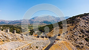 a panoramic view of the ancient centuries-old mills against the backdrop of mountains and olive groves of Crete filmed