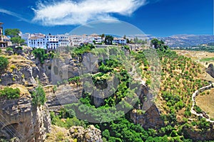 Panoramic view on ancient village Ronda located precariously close to the edge of a cliff, rural agriculture landscape background