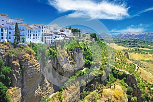 Panoramic view on ancient village Ronda located precariously close to the edge of a cliff, rural agriculture landscape background