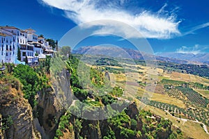 Panoramic view on ancient village Ronda located precariously close to the edge of a cliff, rural agriculture landscape background