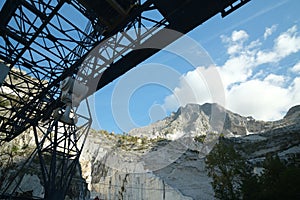 Panoramic view of the Apuan Alps from a quarry of white Carrara marble. A large overhead crane used to move blocks