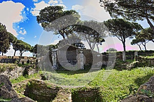 Panoramic view at archeological excavations in Ostia Antica with the sanctuary of Attis with its graven statues surrounded by