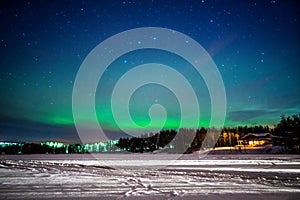 Panoramic view of the Aurora Borealis over a frozen lake in Lapland, Finland