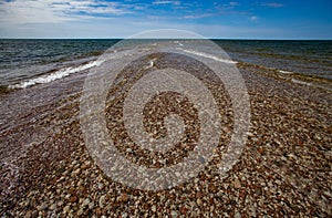 Panoramic view of Baltic sea. Round stones in clear transparent water. Blue sky with clouds