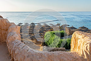 Panoramic view of beach Ras Umm El Sid. Beautiful sunrise over Red Sea with rocky shores, sandy beach with umbrellas and