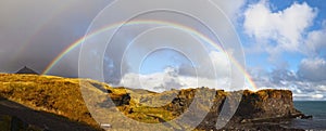 Panoramic view of a beautiful rainbow in the cloudy sky. Snaefellsnes, Iceland.