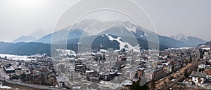 Panoramic view of beautiful town and snowcapped mountains against sky