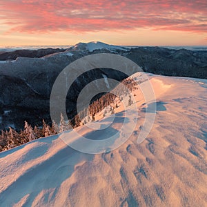 Panoramic view of beautiful winter wonderland mountain scenery in evening light at sunset. Mountains above the clouds. Christmas