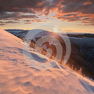 Panoramic view of beautiful winter wonderland mountain scenery in evening light at sunset. Mountains above the clouds. Christmas