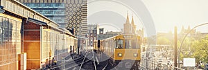 Panoramic view of Berliner U-Bahn with Oberbaum Bridge in the background in golden evening light at sunset with retro vintage