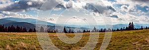 Panoramic view at Beskidy Mountains seen from Rysianka Mountain. Hills covered with forest lightened by sun beams. Beautiful,